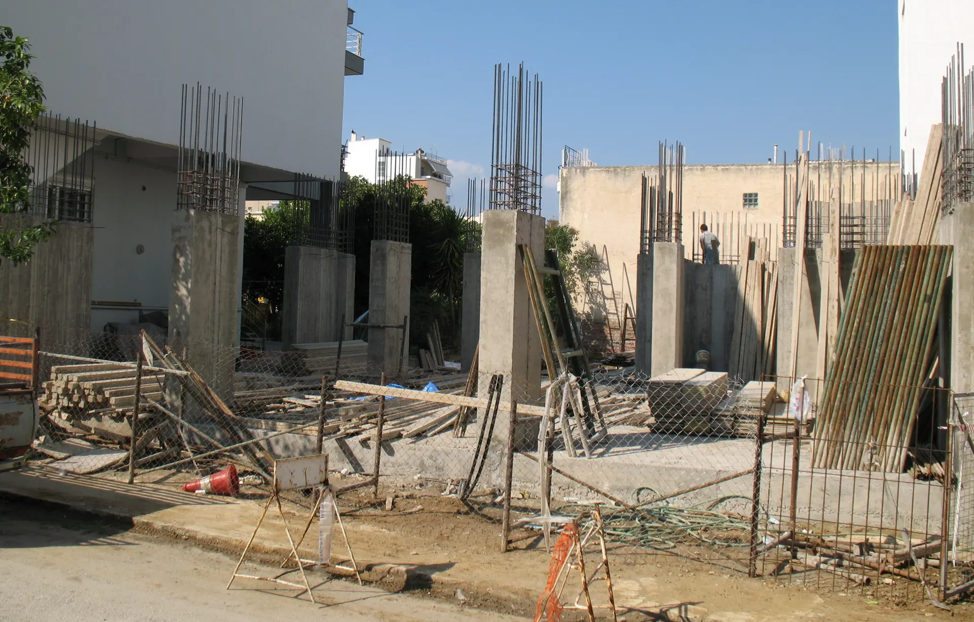 ساختمان بتنی در حال ساخت با اسکلت فلزی و قالببندی، نشاندهنده مراحل اولیه ساختوساز
